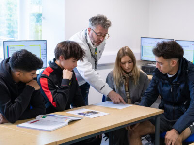 Teacher and a group student in discussion within a lesson