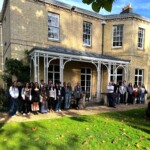 students stand outside a stone building at Cambridge University
