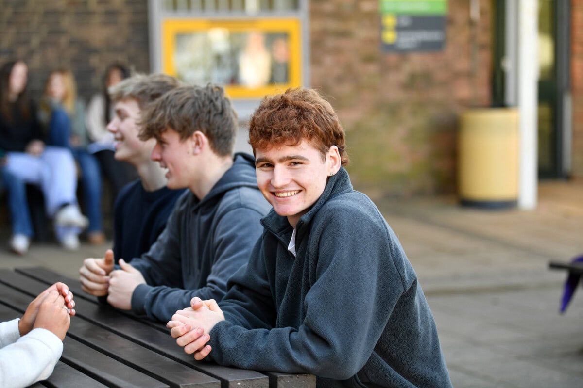 College Student at a bench with other students
