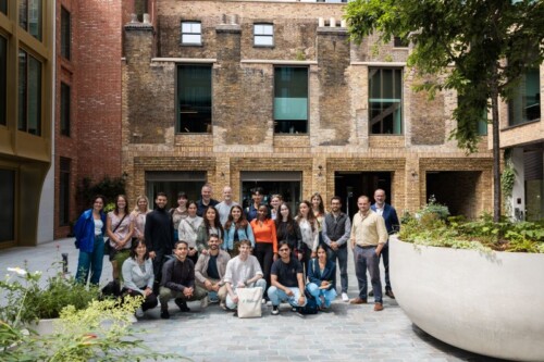 Alumni Ramona outside UCL with a group of her student peers