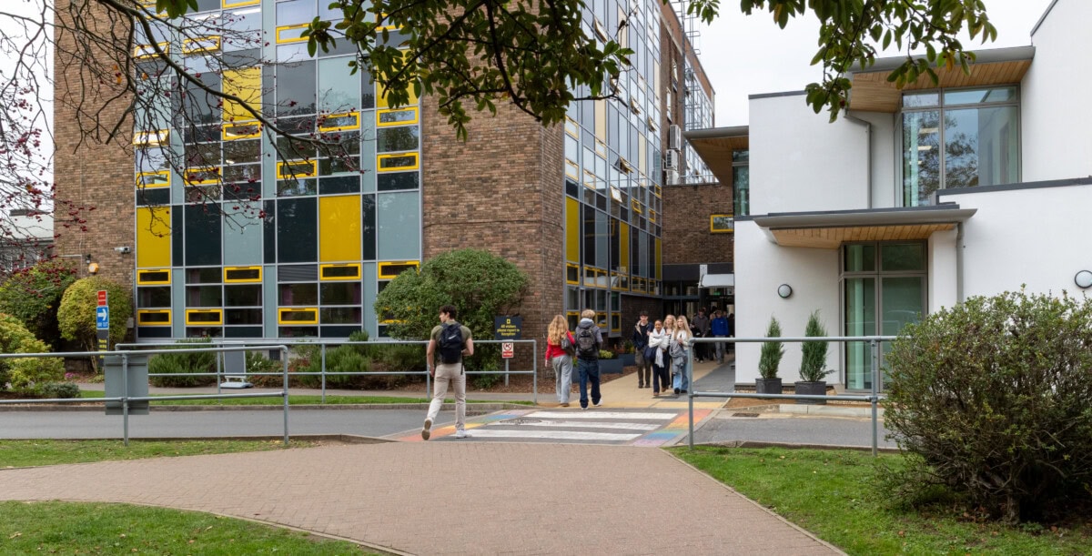 Tower And New Buildings With Students Crossing