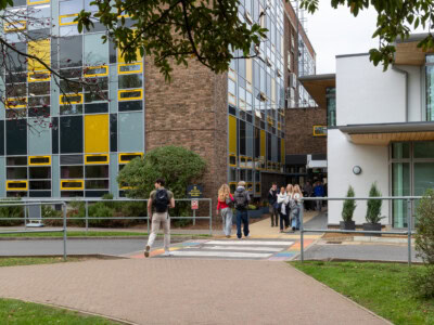 Tower And New Buildings With Students Crossing