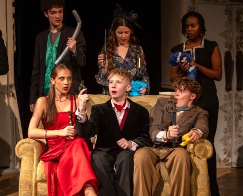 Cast of cluedo holding their weapons