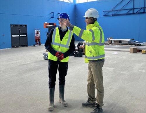 a male student in a hard hat at work experience