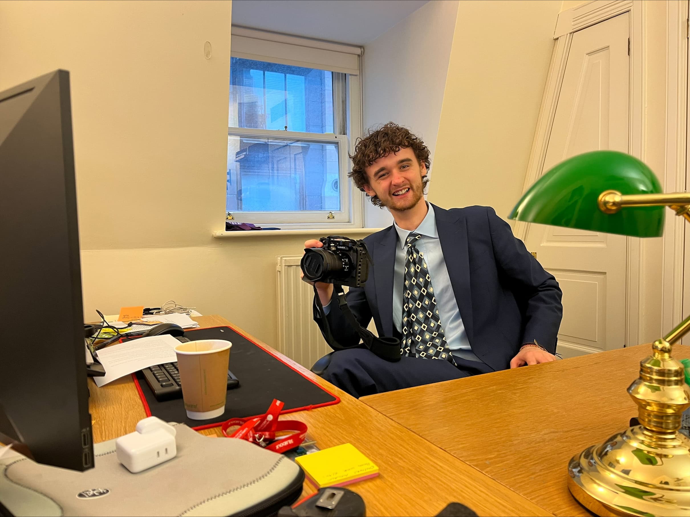 Joe at his desk holding a camera