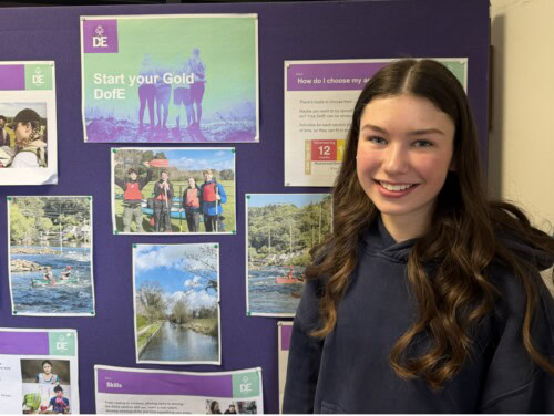 Student standing in front of D of E display board