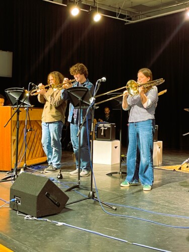 Students playing jazz trumpets on stage
