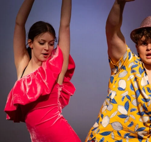 male and female student dancing on stage