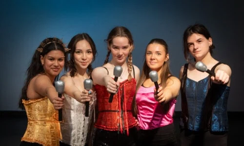 performing arts students singing at a mic