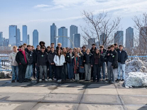 Economics students standing in front of NY city skyline