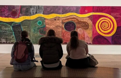 art students observing work in a gallery