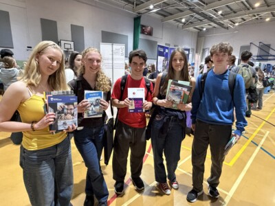 Group of students holding prospectuses