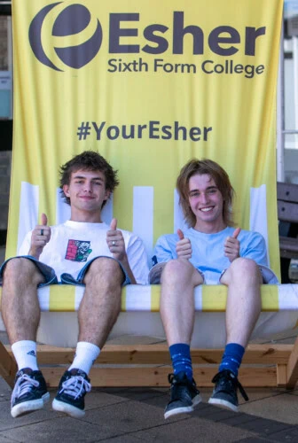 two boys sit in a giant yellow deck chair