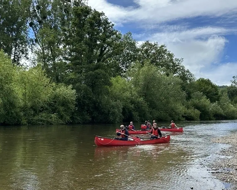 students sitting in canoes on the river wye 