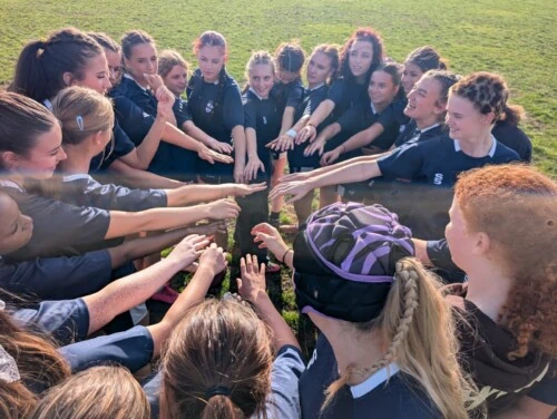 Esher and Godalming rugby girls in a huddle