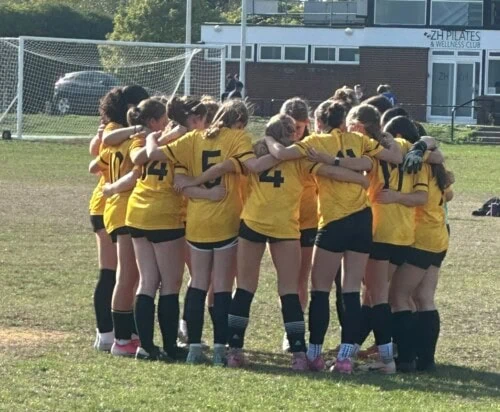 Women's football in a huddle