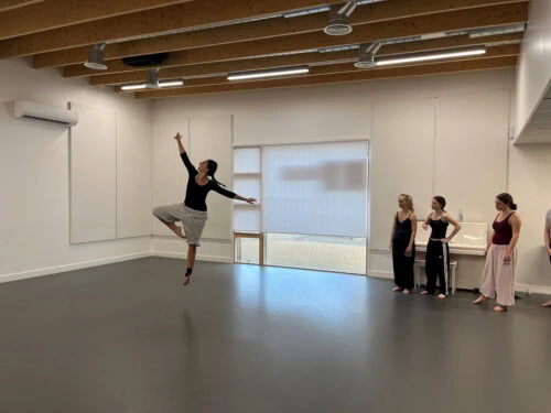 Derin Lastan leaping through the air in the dance studio